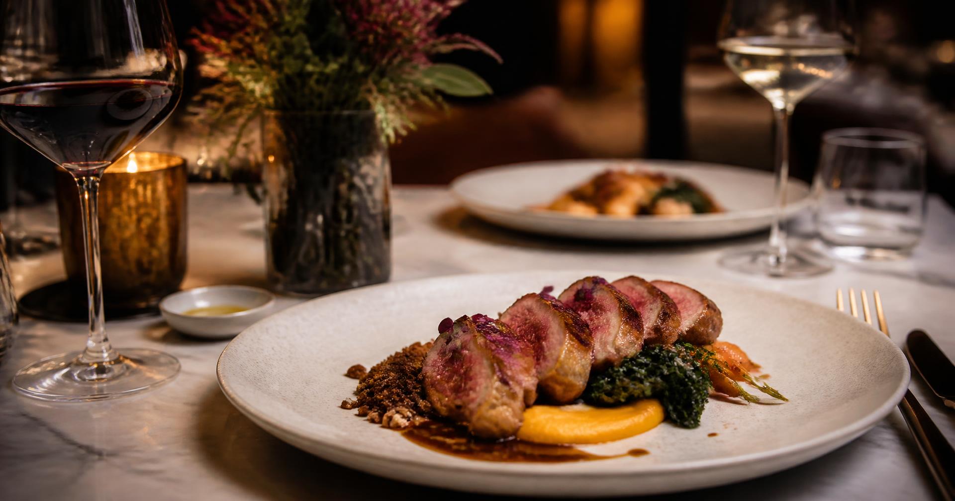 Chef-prepared entrée plated at a candlelit restaurant table