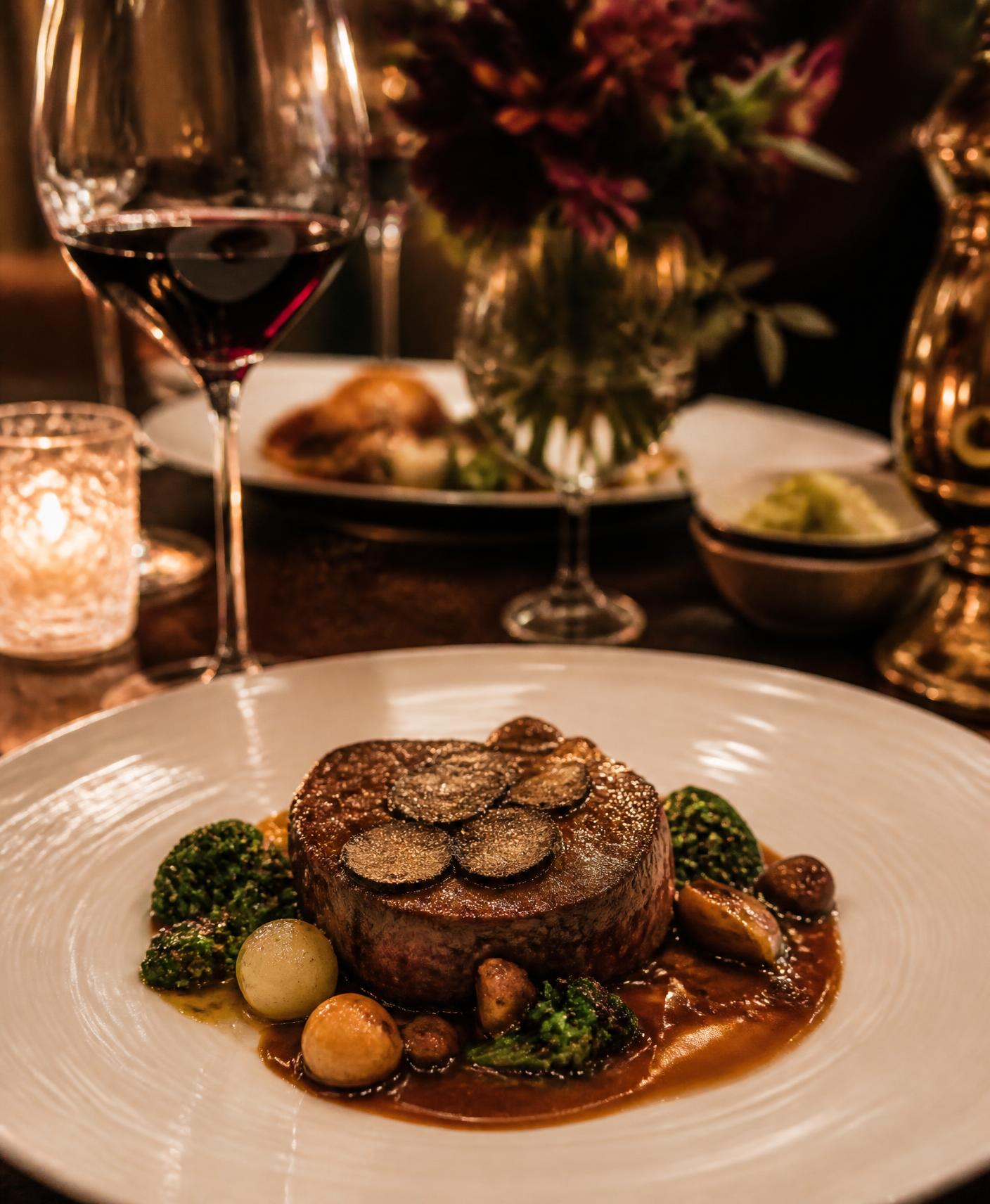 Plated fine-dining entrée on a candlelit restaurant table